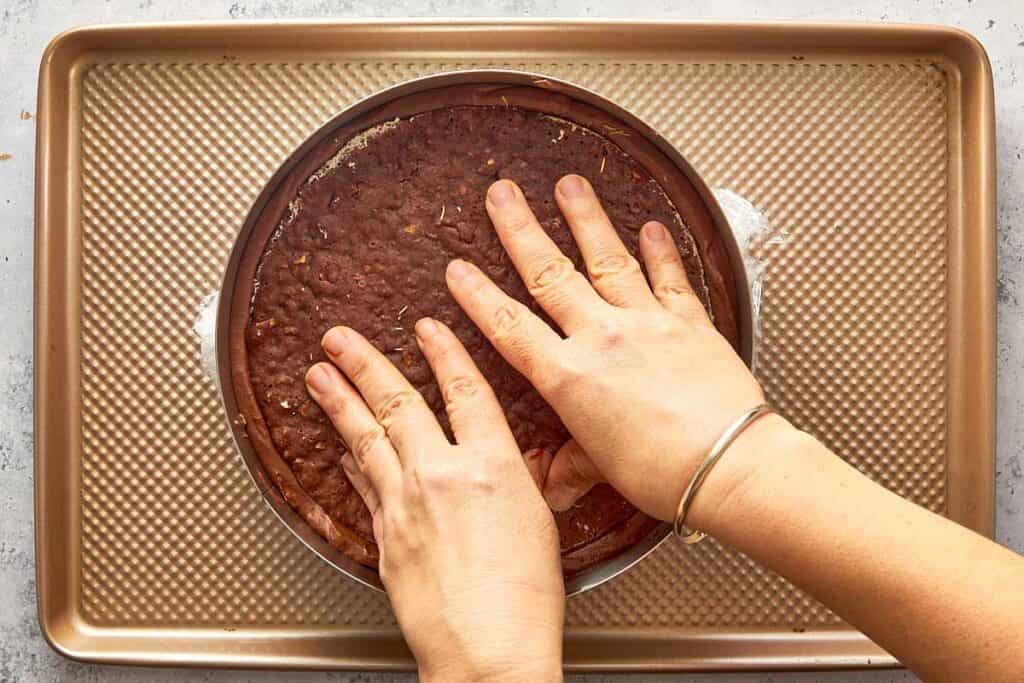 pressing down the pistachio chocolate disk creating another layer of texture to the cake