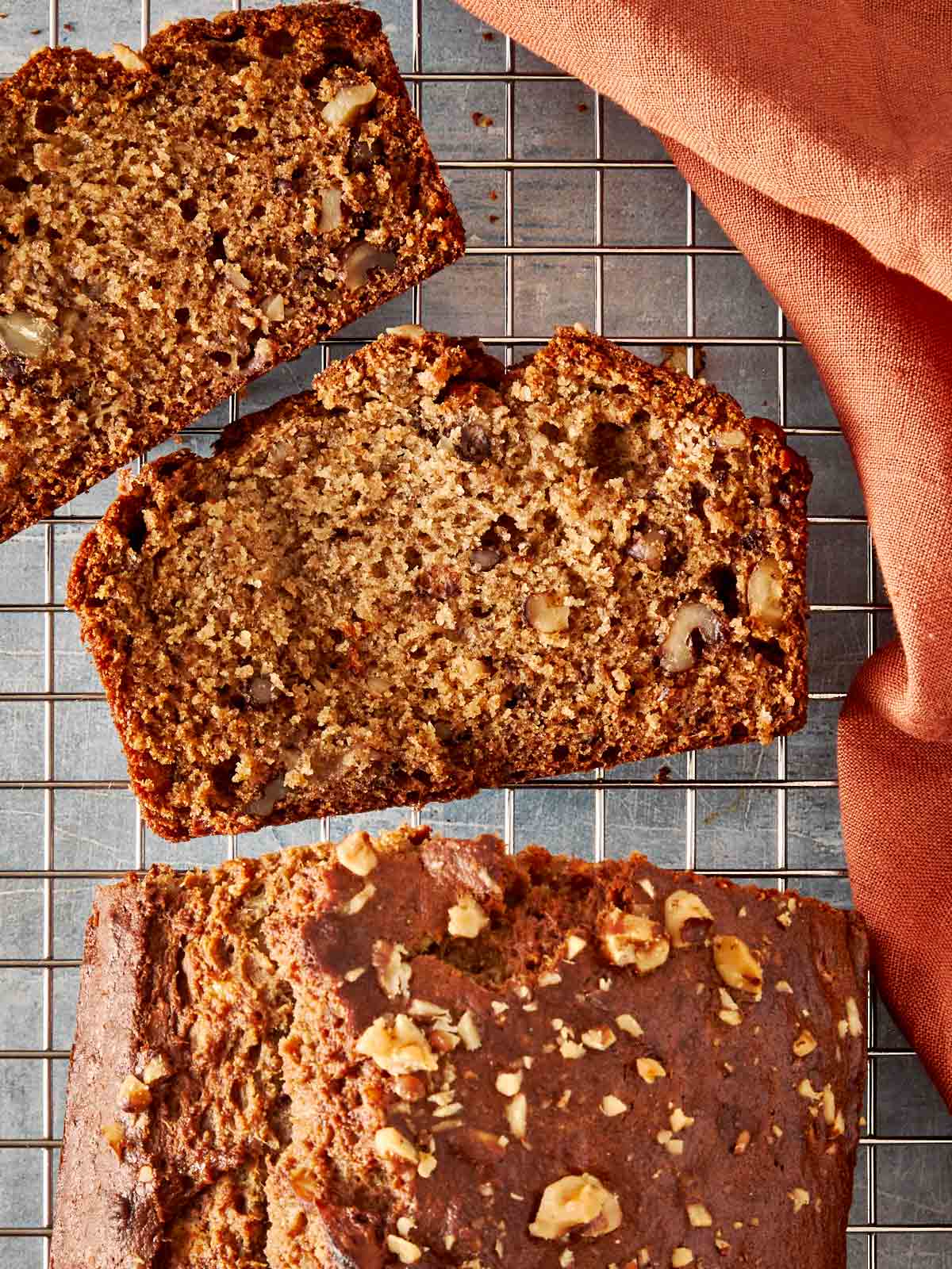 a top down view of slices of brown banana bread resting on a wire tray  - 1