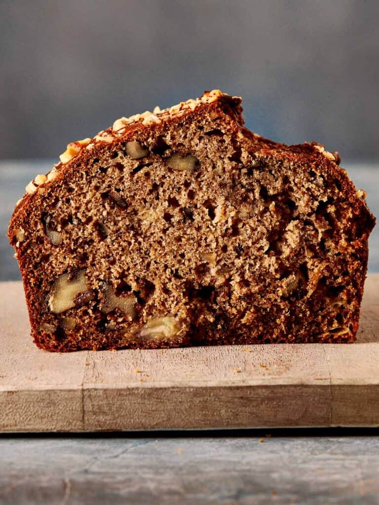 a side view of a slice of banana bread sitting on top of a board