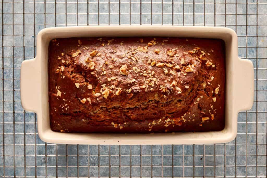 a top down view of banana bread baked in a rectangular loaf pan resting on a wire tray cooling - 10