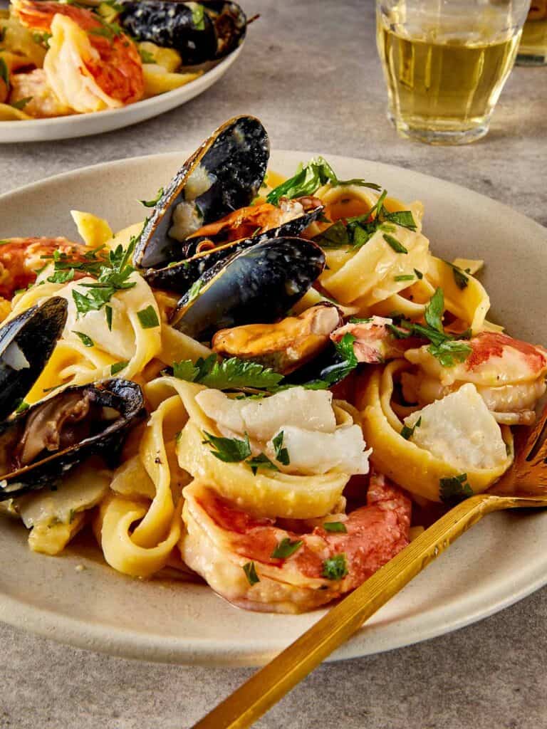 a side view of a pasta and seafood dish that looks creamy - 1
