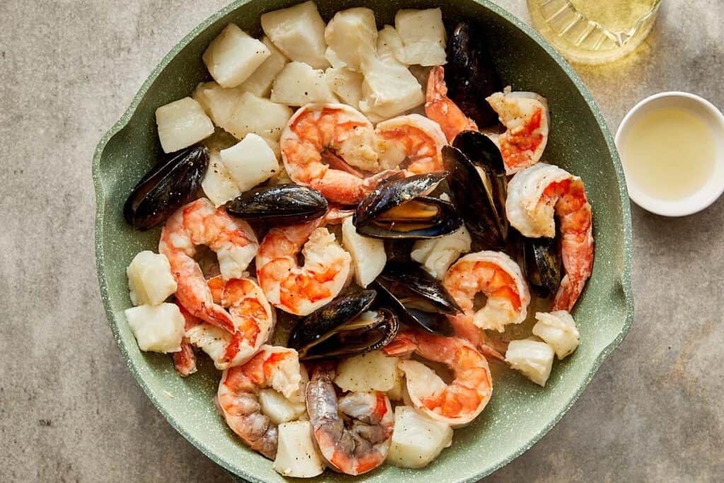 a top down view of a plate full of seafood an being cooked - 6