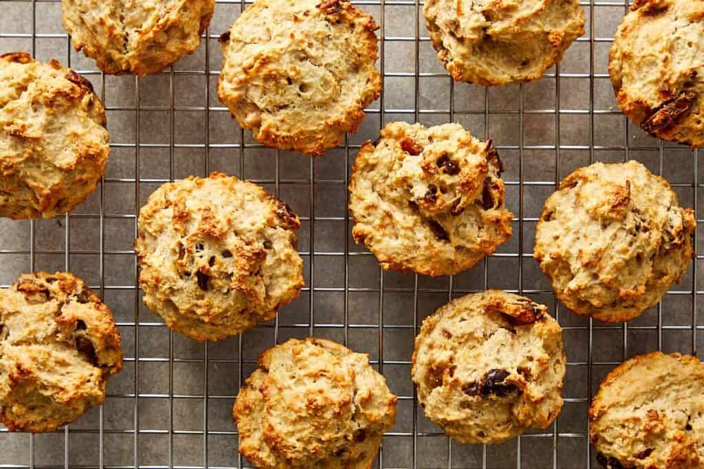 a collection of muffins sitting spaced out on a wire rack cooling - 11