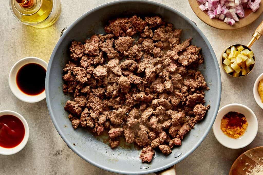 a top down view of a pan filled with mince meat being cooked on a benchtop stove, the meat is browning up - 6