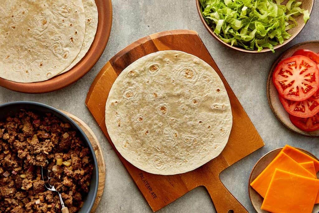 a top down view of a wrap on top of a wooden board sitting on a kitchen bench, the wrap is empty - 9