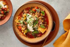served lasagna soup topped with ricotta, parmesan, fresh parsley and basil.