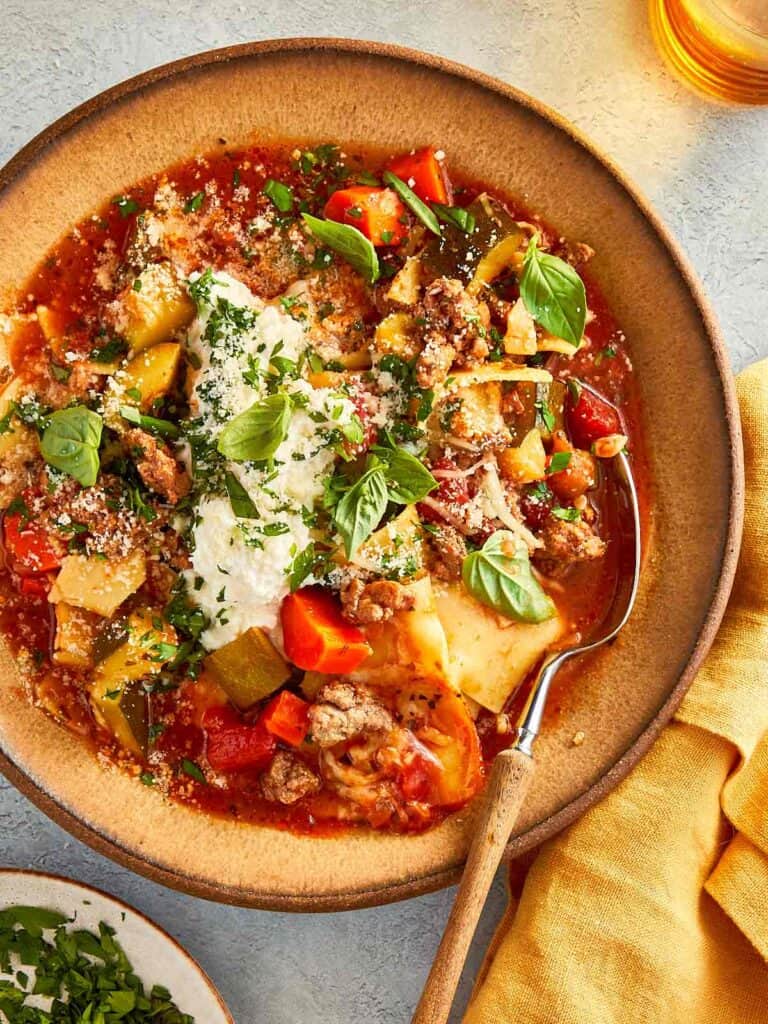 top overview of lasagna soup served with ricotta and parmesan cheese and topped with basil and parsely. - 15