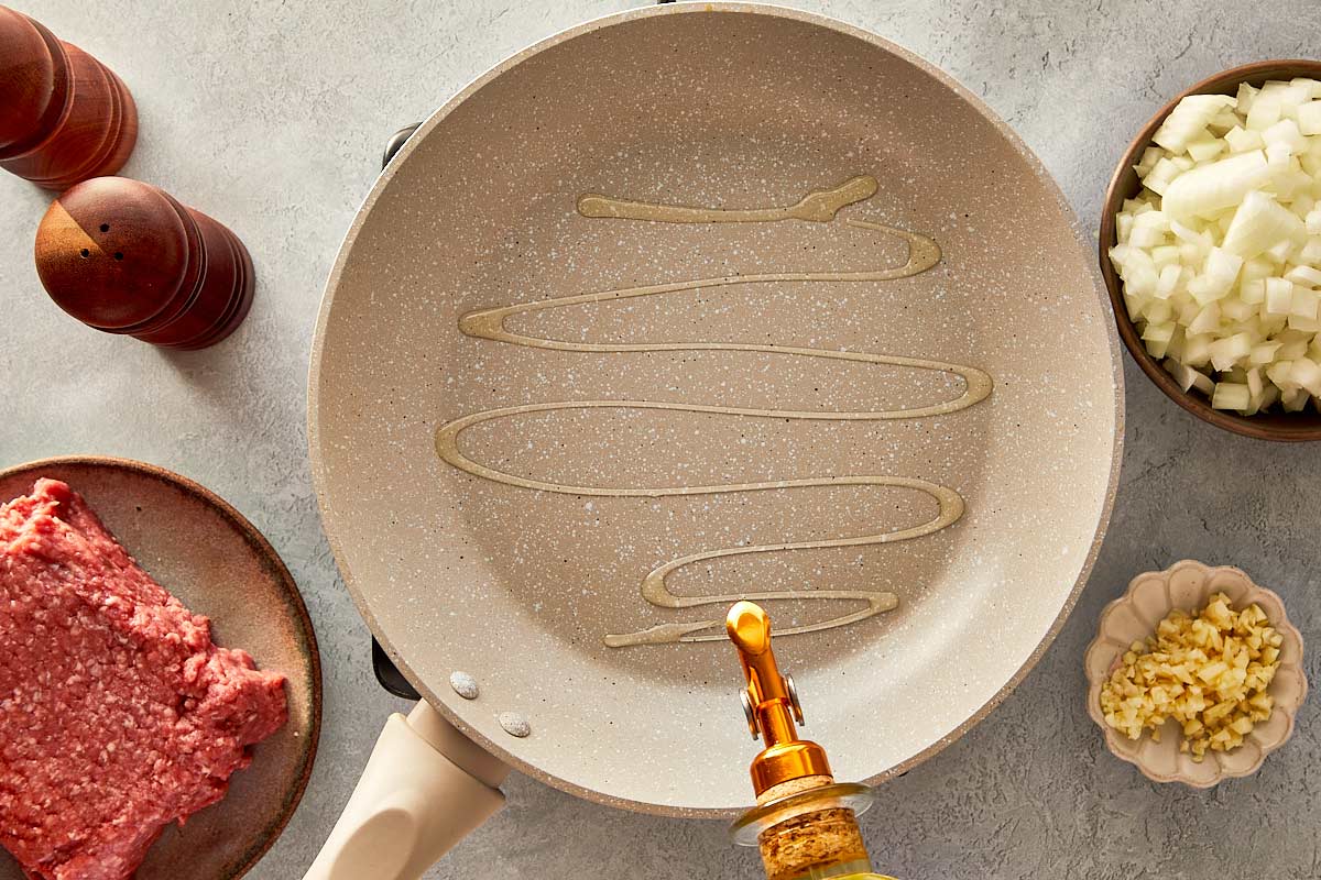 top overview of beige pan being drizzle with olive oil - 3