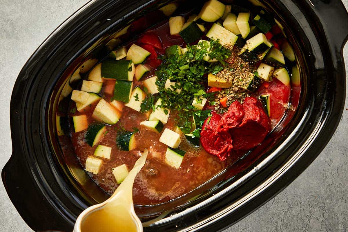 top overview of chicken stock being pour into the slowcooker - 9