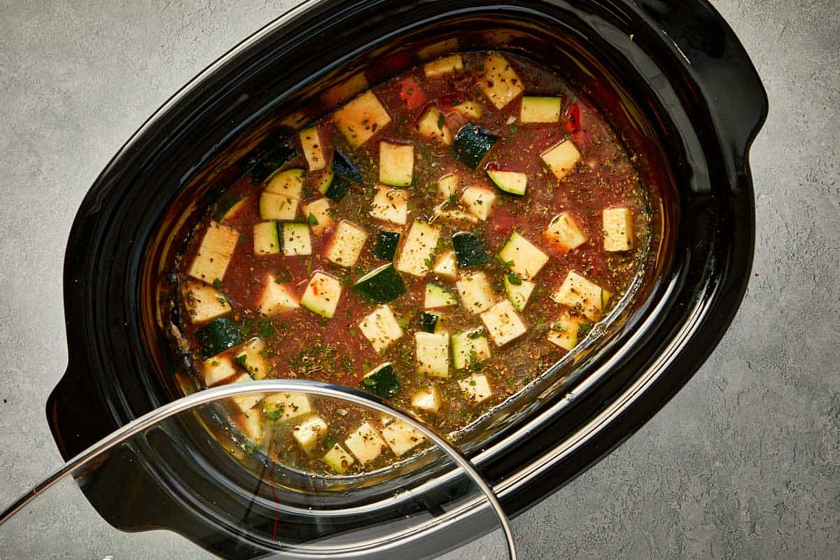 top overview of lasagna soup being covered and cooked in the slowcooker. - 10