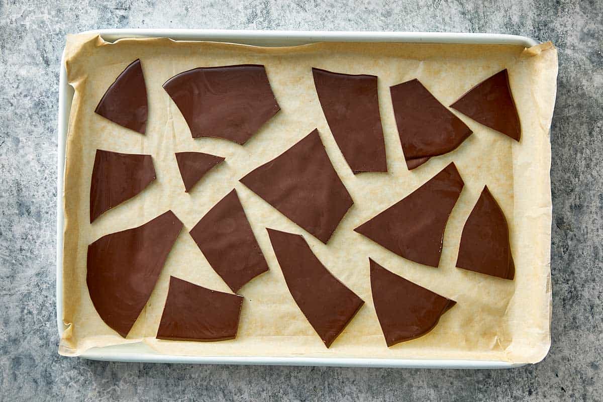 Top overview of broken chocolate chips in a lined tray.