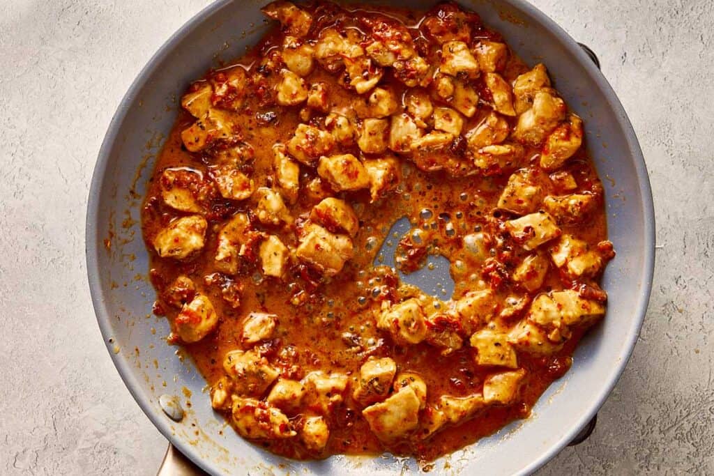 a top down view of chicken pieces coated in spices that have been fried in the pan.