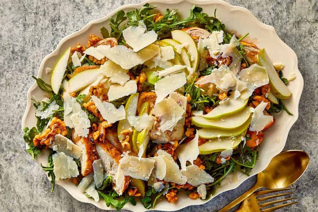 Arugula salad topped with grilled chicken, fresh pear slices, caramelized walnuts, and shaved parmesan.