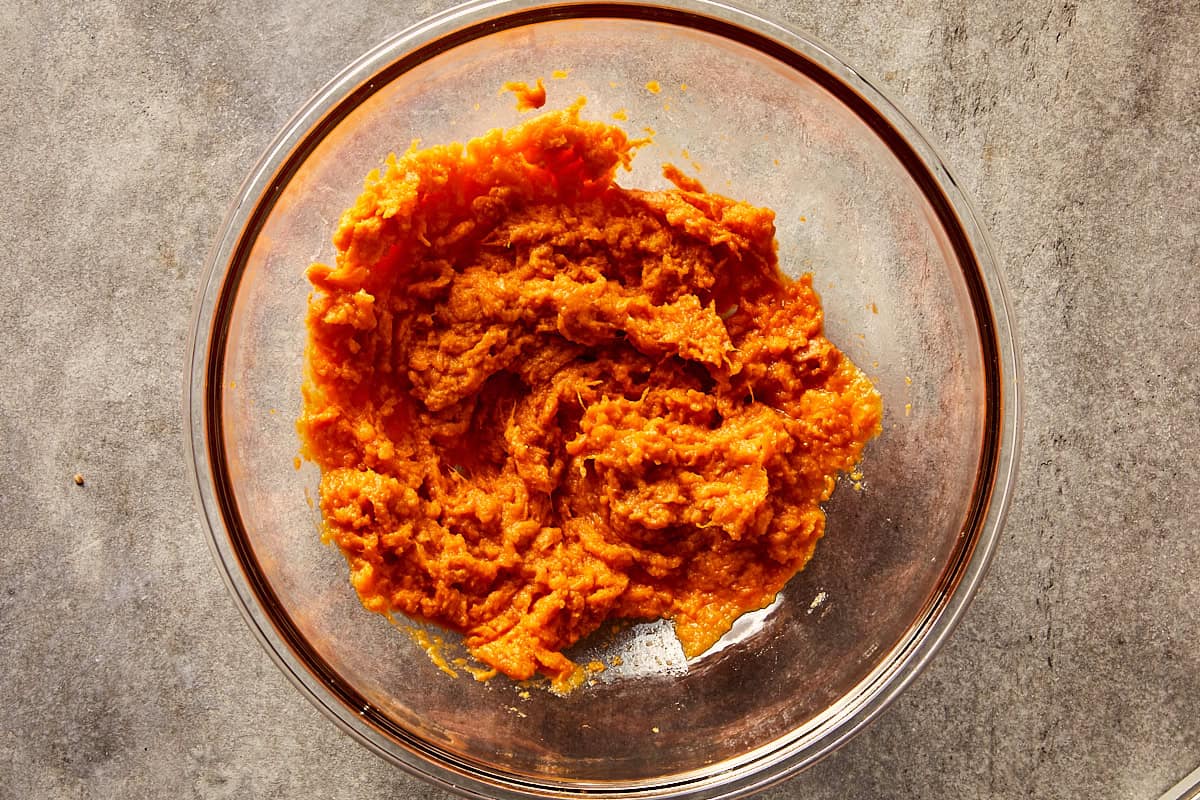 Mashed sweet potato in a bowl in a grey surface