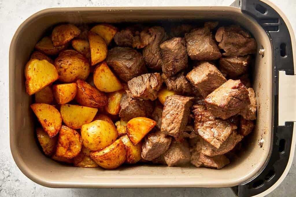 Top overview of potatoes and cooked steak in the air-fryer