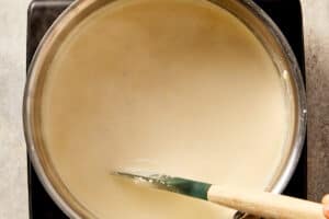 Light cream, cream cheese, and chicken stock whisked together in a pan until smooth and creamy