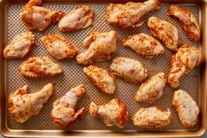 seasoned chicken wings arranged on baking sheet for oven