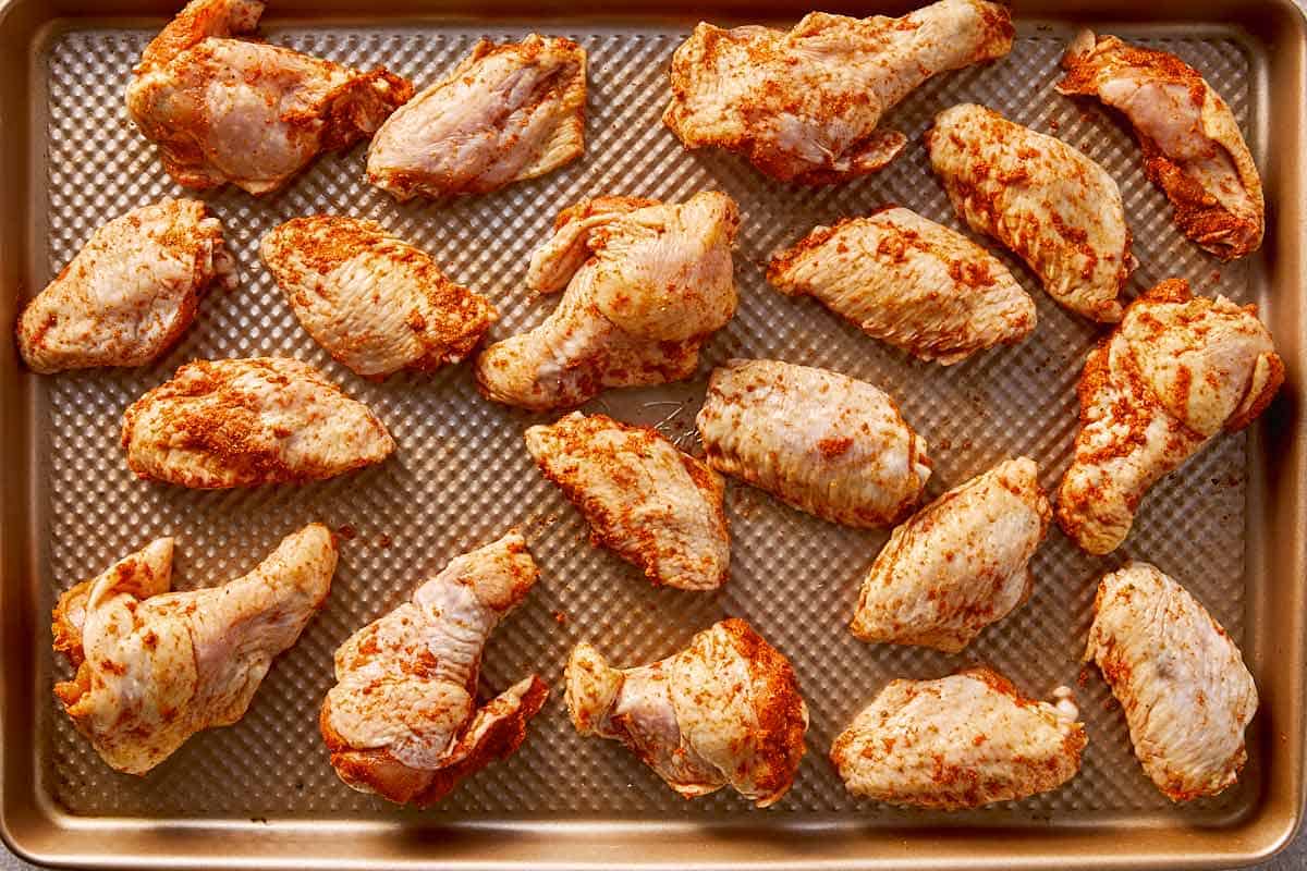 seasoned chicken wings arranged on baking sheet for oven