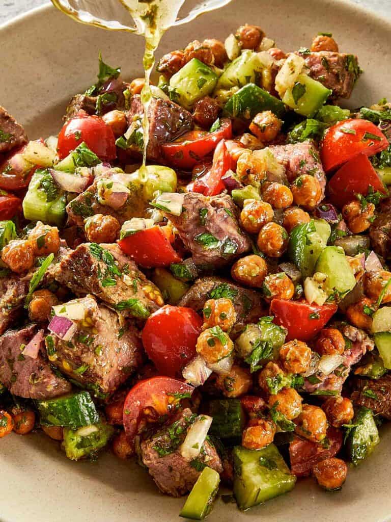 steak and chickpea salad with crispy roasted chickpeas tomatoes cucumber avocado and chimichurri