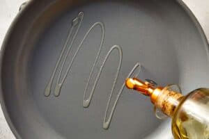 Skillet being drizzled with olive oil