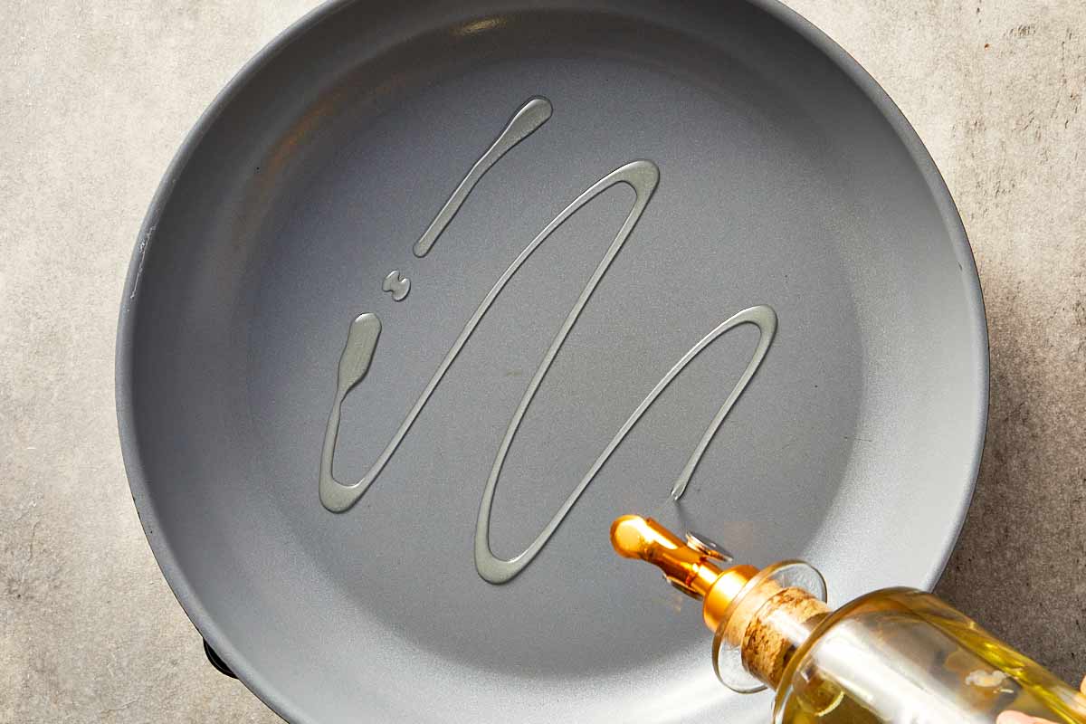 Overview top of a pan being drizzle with olive oil