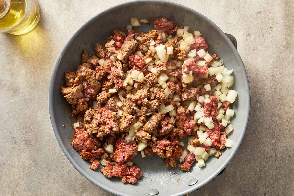 Top overview pf ground beef being cooked in a pan with onion.
