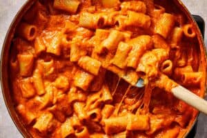 Creamy tomato mac and cheese as the pasta finishes cooking directly in the sauce, creating a rich, thick texture with perfectly coated noodles.