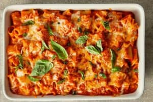 Tomato soup mac and cheese baked until golden and bubbly, topped with melted cheese and fresh basil.