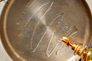 Olive oil drizzled into a pan over medium heat before cooking ingredients