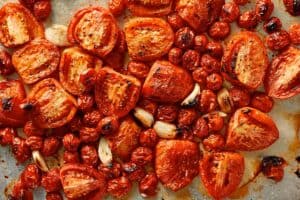 Roasted Roma and cherry tomatoes with garlic, caramelized and slightly charred after baking with olive oil, salt, and pepper.