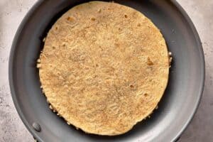 Chicken smashed taco cooking chicken-side down in a pan