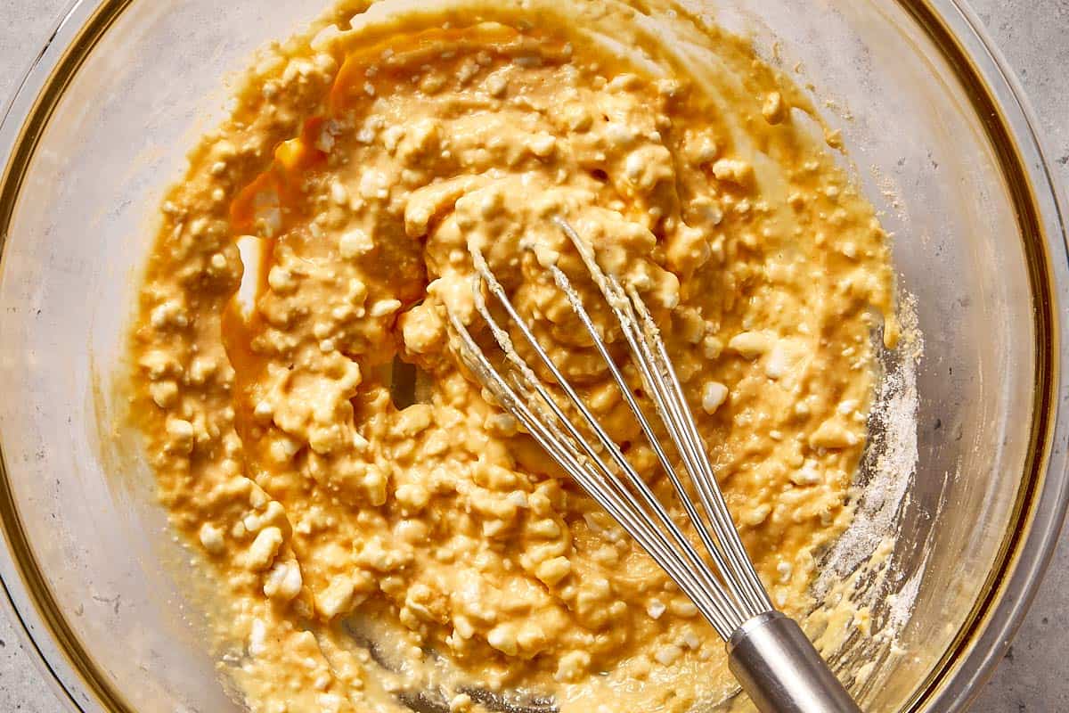 Cottage cheese pancake batter being mixed in a bowl, showing a thick, slightly lumpy texture before blending.