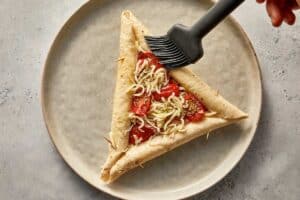 Adding egg wash to the tortilla pizza crusts