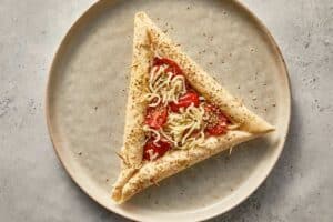 Raw tortilla pizza with sesame seeds, oregano and basil
