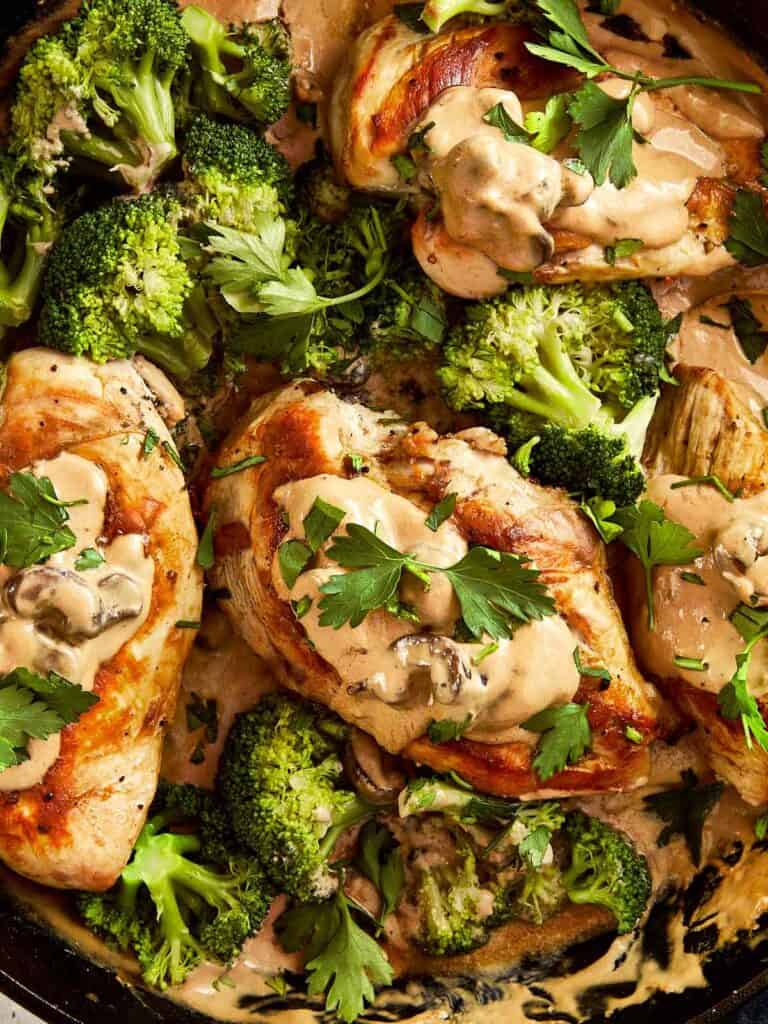 Image focusing on chicken pieces from Julia Child's Creamy Chicken + Mushroom in a pan