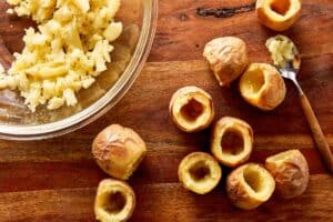 Baked baby potatoes hollowed out with centers scooped into a bowl, ready to be filled for deviled potatoes
