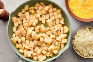 Diced potatoes starting to cook in olive oil in a pan