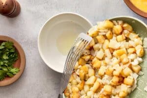 Draining excess oil from cooked potatoes and onions