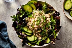tuna salad for one served over greens with cucumber slices