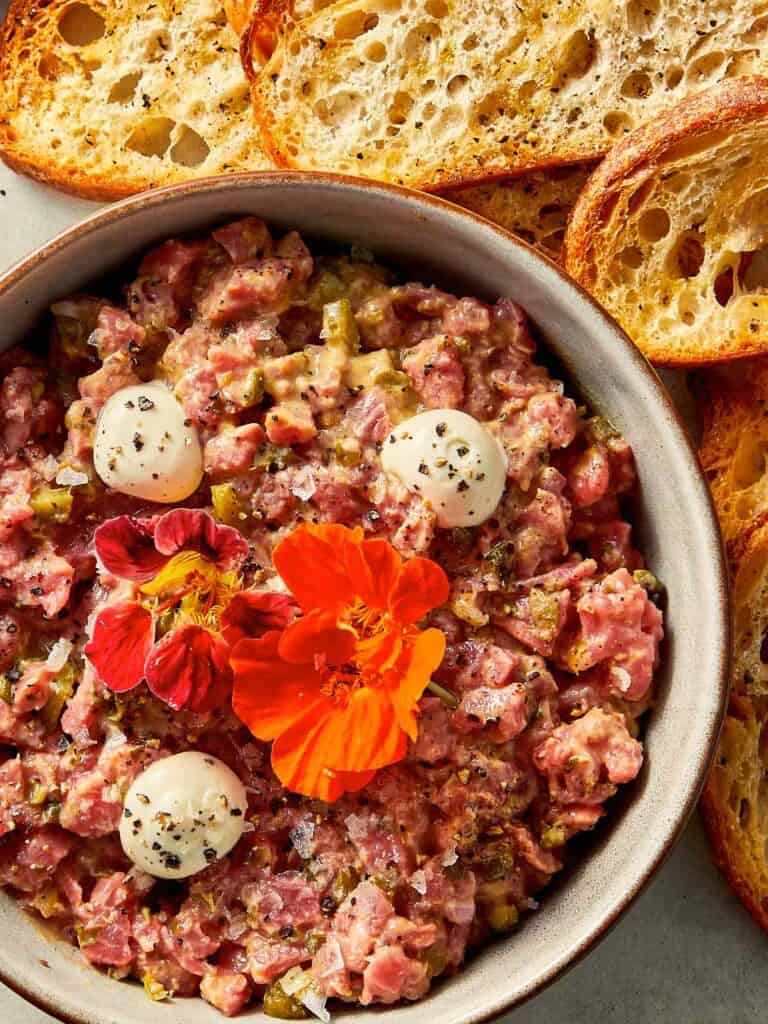 Steak tartare in a bowl with toast at the side ready to be eaten