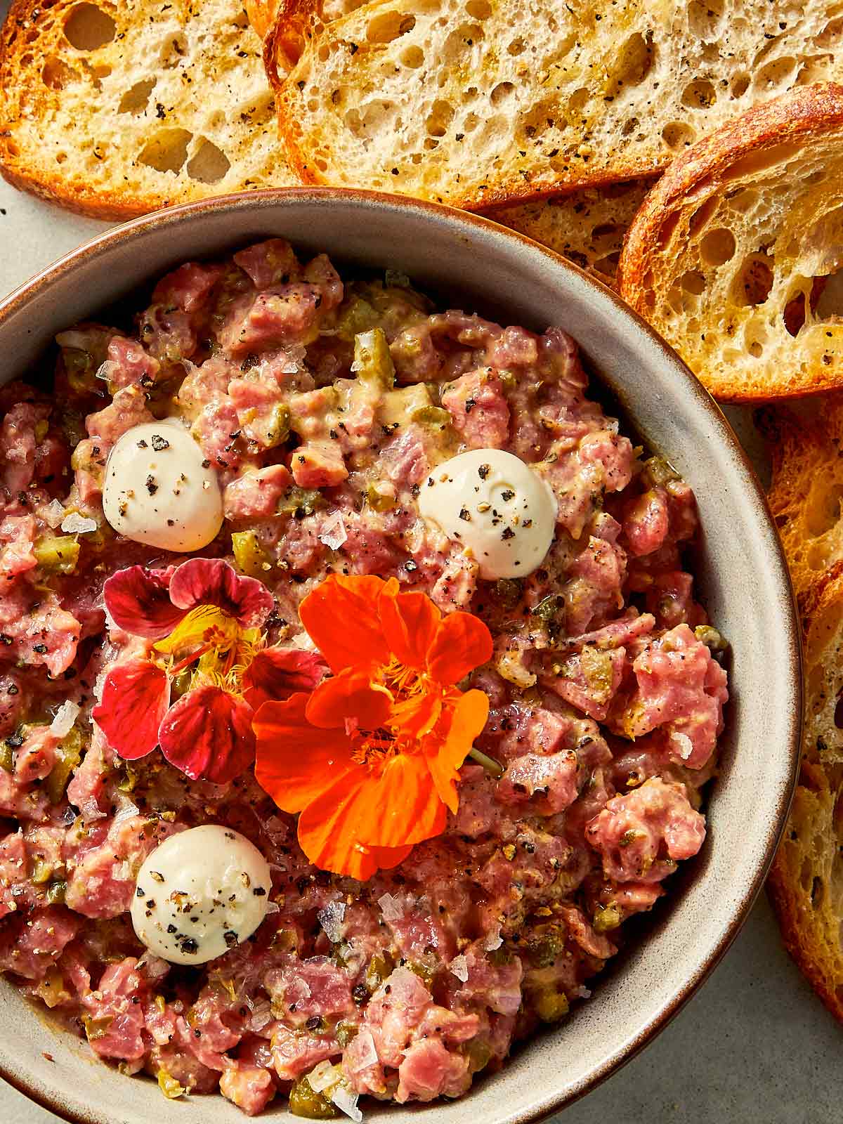 Steak tartare in a bowl with toast at the side ready to be eaten