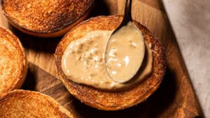 halved bun being spread with the burger sauce