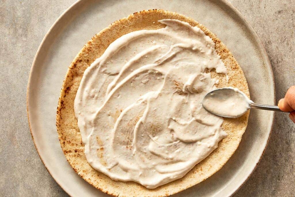 Bread being spread with tahini