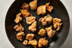 cooking chicken thighs in a pan with oil