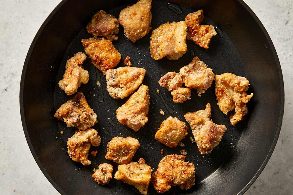 cooking chicken thighs in a pan with oil