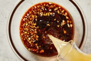 Pouring chicken broth in the homemade sesame sauce