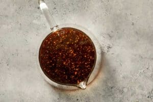 Pomegranate molasses dressing mixed in a small glass pouring jug.