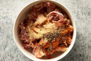 seasoning the chicken in a bowl