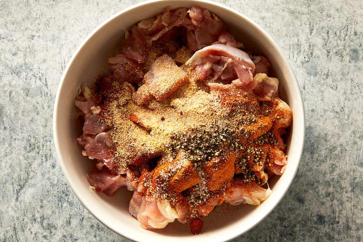 seasoning the chicken in a bowl