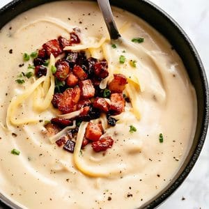 Cauliflower soup ready to eat with bacon, cheese and chives